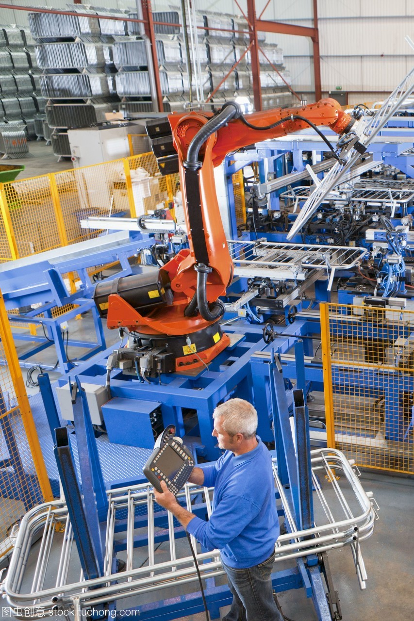 工人在制造工廠的生產線上控制機械吊裝